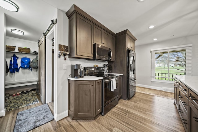 11378 Ann Dr NW, Baltimore, OH 43105 - kitchen featuring stainless steel microwave, light countertops, black electric range oven, a barn door, and fridge