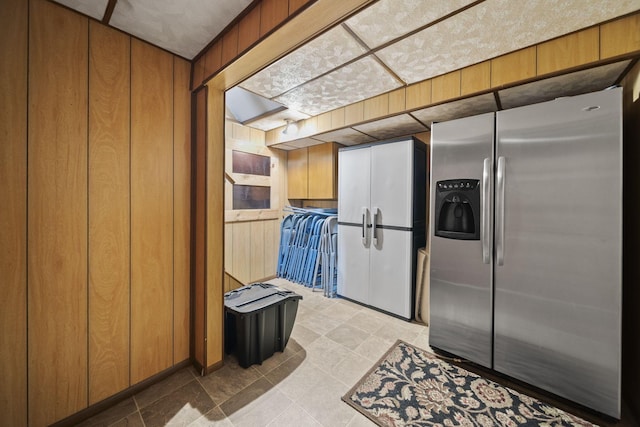 11378 Ann Dr NW, Baltimore, OH 43105 - kitchen featuring brown cabinets, stainless steel fridge with ice dispenser, and wooden walls