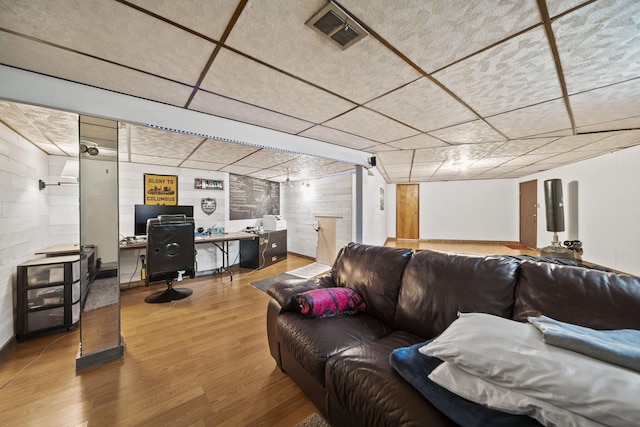 11378 Ann Dr NW, Baltimore, OH 43105 - living room with visible vents, concrete block wall, a drop ceiling, and wood finished floors