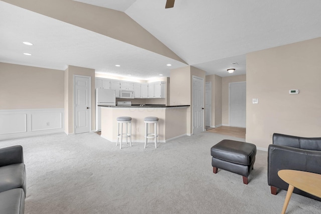 living area featuring recessed lighting, vaulted ceiling, light colored carpet, and ceiling fan