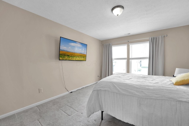 bedroom featuring visible vents, baseboards, carpet, and a textured ceiling