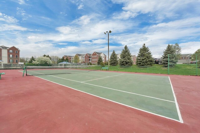view of tennis court featuring fence