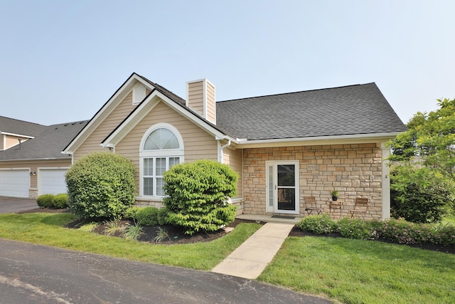 8050 Flint Run Pl, Columbus, OH 43235 - view of front of home featuring stone siding, a chimney, a front yard, and a shingled roof