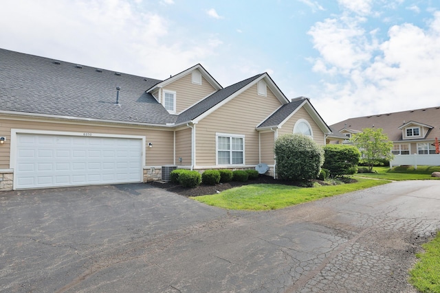 8050 Flint Run Pl, Columbus, OH 43235 - traditional home featuring driveway, central AC unit, stone siding, and roof with shingles