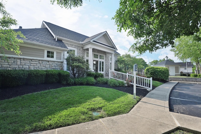 8050 Flint Run Pl, Columbus, OH 43235 - view of front of property with stone siding, a front yard, and a shingled roof