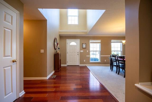 foyer with wood finished floors, visible vents, and baseboards