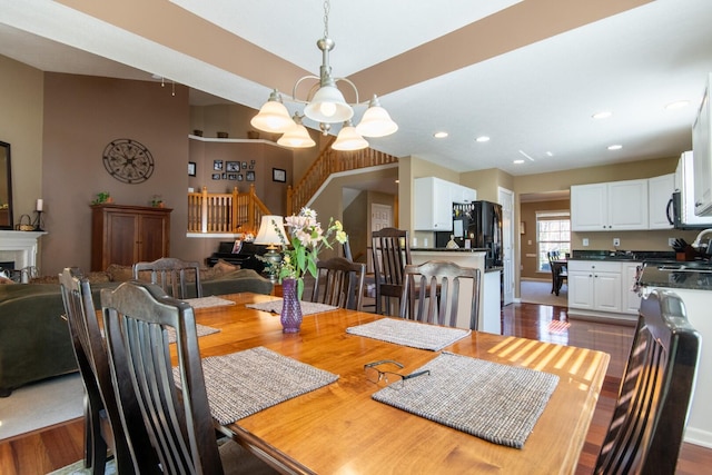 dining space featuring stairs, a notable chandelier, dark wood-type flooring, and recessed lighting