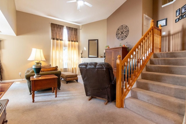 carpeted living area featuring high vaulted ceiling, ceiling fan, baseboards, and stairs