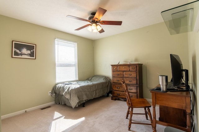 bedroom with light colored carpet, ceiling fan, baseboards, and visible vents
