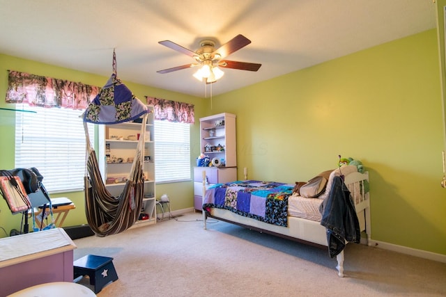 carpeted bedroom with a ceiling fan and baseboards