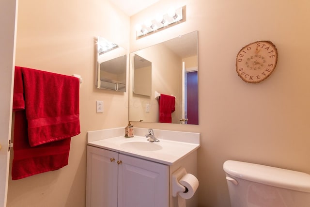 half bathroom featuring vanity and toilet