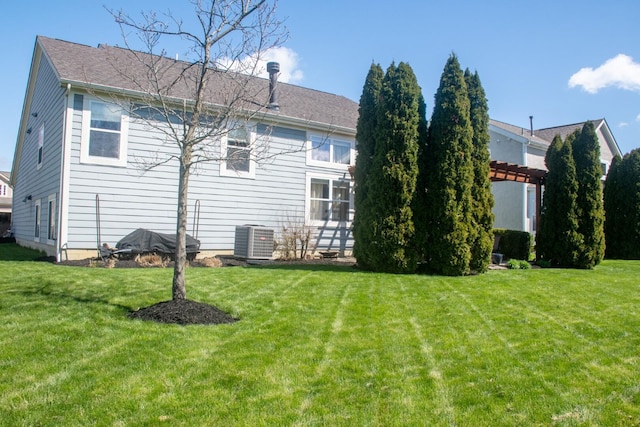back of house featuring central AC unit, a pergola, and a yard