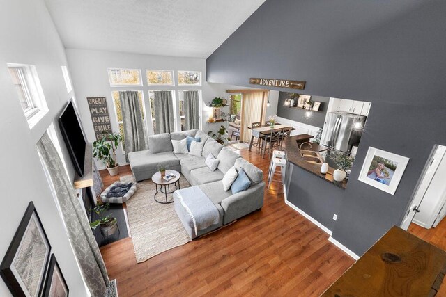 3379 Fishinger Mill Dr, Hilliard, OH 43026 - living room with high vaulted ceiling, wood finished floors, and a textured ceiling