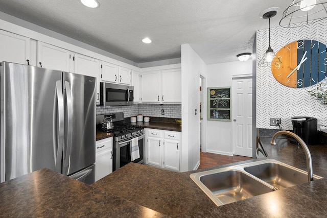 3379 Fishinger Mill Dr, Hilliard, OH 43026 - kitchen with appliances with stainless steel finishes, a sink, dark countertops, white cabinetry, and a textured ceiling