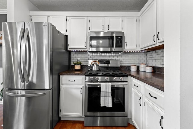 3379 Fishinger Mill Dr, Hilliard, OH 43026 - kitchen with stainless steel appliances, dark countertops, backsplash, and white cabinetry
