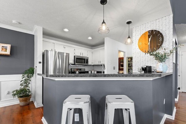 3379 Fishinger Mill Dr, Hilliard, OH 43026 - kitchen featuring appliances with stainless steel finishes, tasteful backsplash, dark wood-style floors, white cabinetry, and dark countertops