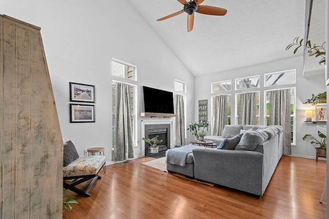 3379 Fishinger Mill Dr, Hilliard, OH 43026 - living room featuring high vaulted ceiling, a ceiling fan, wood finished floors, a fireplace, and baseboards
