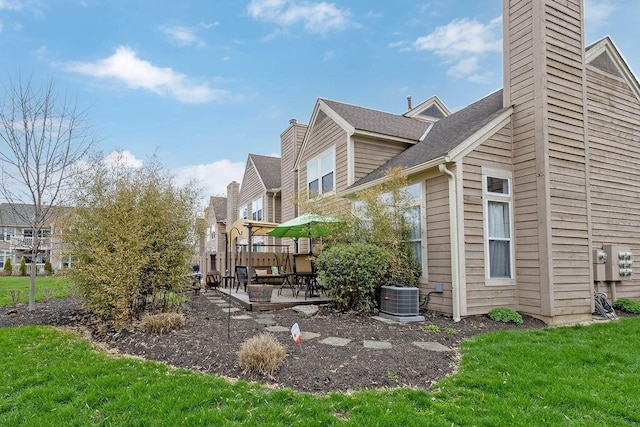 3379 Fishinger Mill Dr, Hilliard, OH 43026 - view of side of home with a chimney, a patio, central AC unit, a yard, and a shingled roof