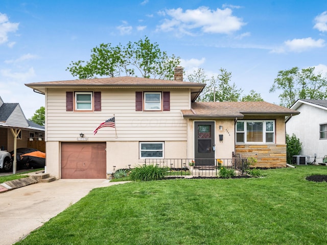 split level home with a chimney, an attached garage, driveway, a front lawn, and stucco siding