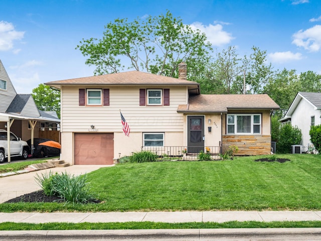 split level home with a garage, driveway, central AC unit, a chimney, and a front yard