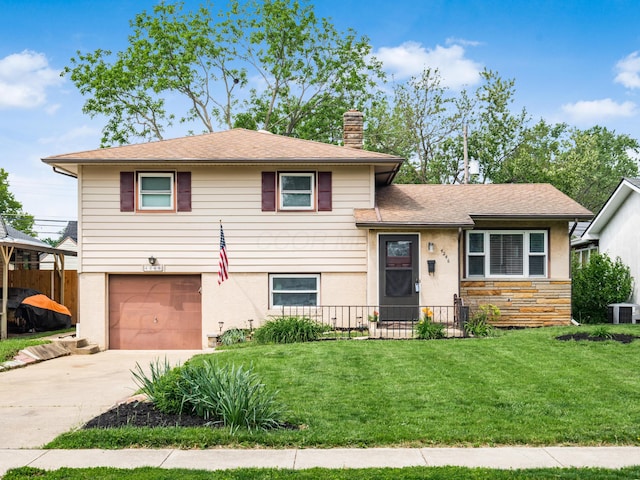 tri-level home with a garage, a chimney, concrete driveway, central air condition unit, and stucco siding
