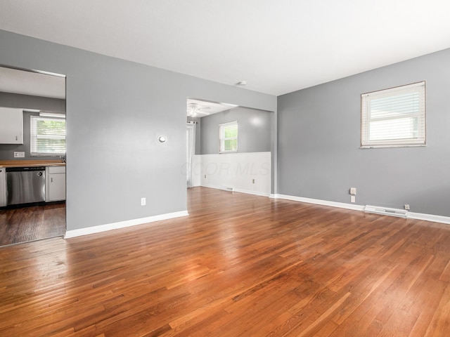 spare room with hardwood / wood-style flooring, plenty of natural light, and baseboards