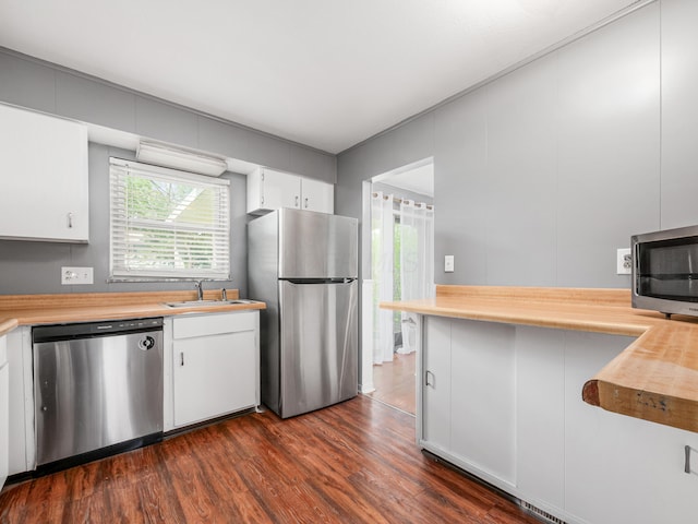 kitchen featuring stainless steel appliances, a sink, dark wood-style flooring, and healthy amount of natural light