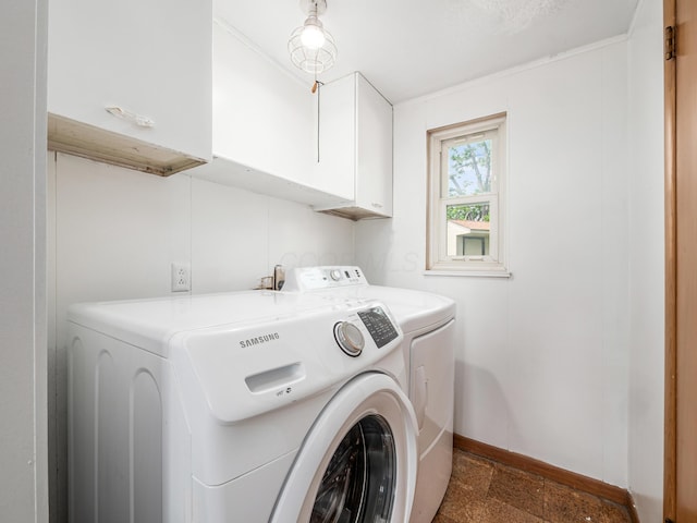 laundry room featuring cabinet space, washing machine and dryer, and baseboards