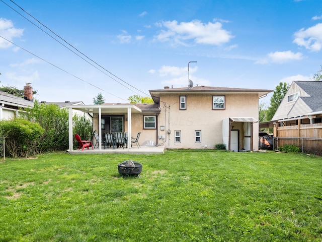 rear view of house featuring a fire pit, stucco siding, and a patio area