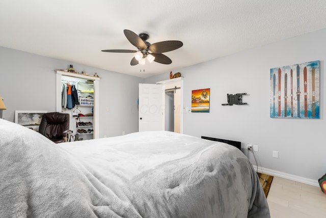 1706 Kinross Ln, Galloway, OH 43119 - bedroom featuring a barn door, baseboards, a closet, ceiling fan, and a walk in closet