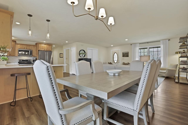 dining space featuring dark wood-type flooring, recessed lighting, and a chandelier