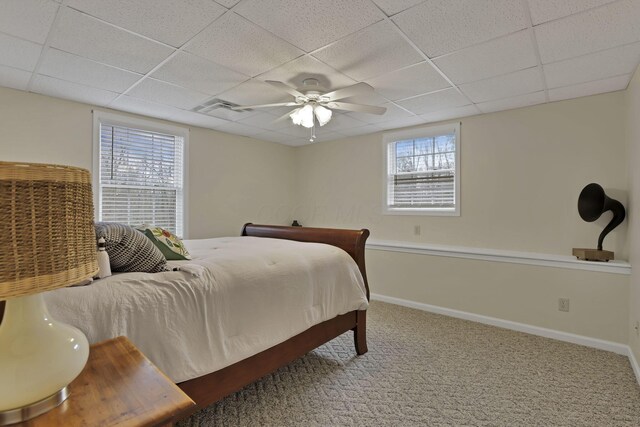 bedroom with a paneled ceiling, multiple windows, and visible vents