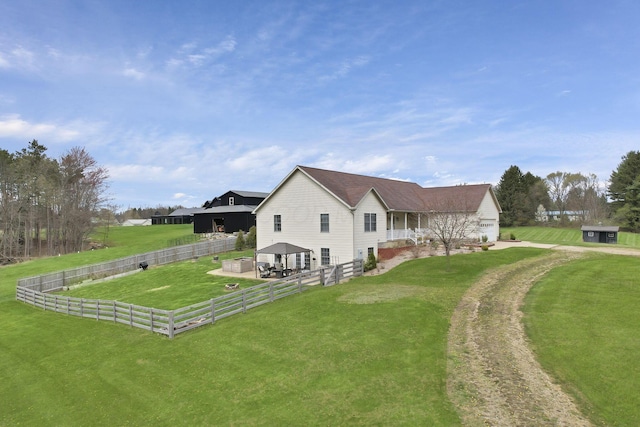 view of home's exterior with a gazebo, fence, and a yard