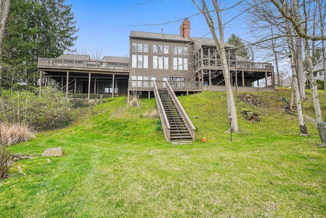 rear view of property featuring stairway, a shingled roof, a chimney, and a deck