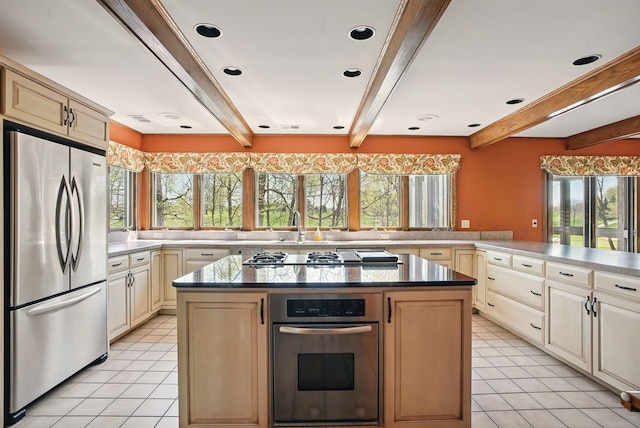 kitchen featuring beam ceiling, stainless steel appliances, and light tile patterned floors