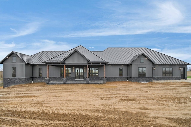 rear view of house with metal roof and a standing seam roof