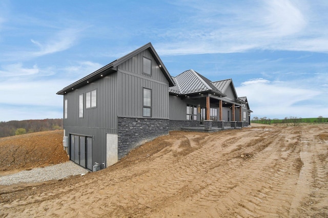 view of side of property with board and batten siding, metal roof, and a standing seam roof
