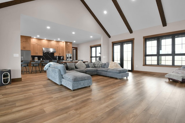 living area featuring beamed ceiling, high vaulted ceiling, recessed lighting, and light wood finished floors