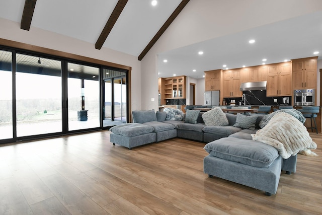 living area featuring light wood-style flooring, high vaulted ceiling, beamed ceiling, and recessed lighting