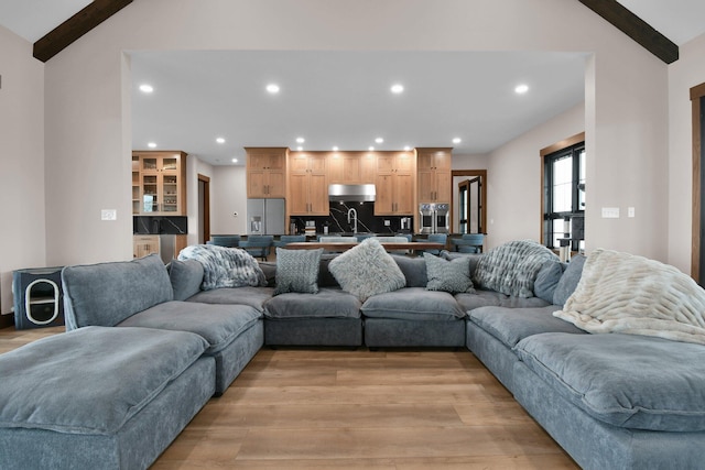 living area with light wood finished floors, vaulted ceiling with beams, and recessed lighting