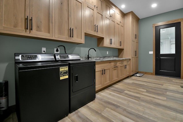 kitchen featuring light brown cabinets, a sink, light wood finished floors, recessed lighting, and washing machine and clothes dryer