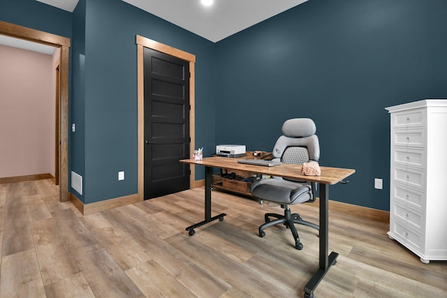 office area featuring visible vents, light wood-style flooring, and baseboards