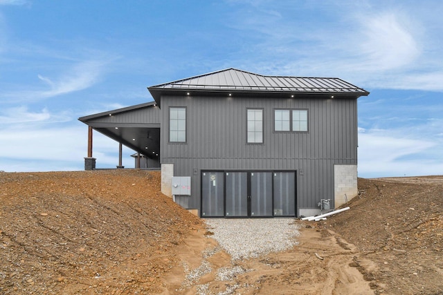 rear view of property with metal roof and a standing seam roof