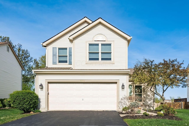 traditional-style home featuring an attached garage and aphalt driveway