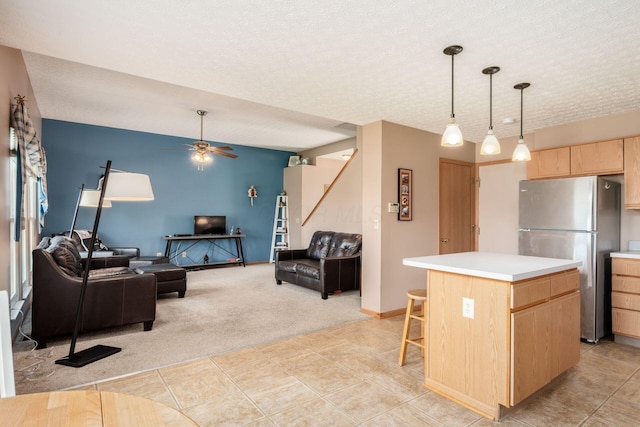 kitchen with freestanding refrigerator, light brown cabinetry, light carpet, open floor plan, and light countertops