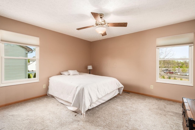 bedroom featuring carpet floors, a textured ceiling, baseboards, and ceiling fan
