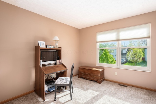 office area featuring baseboards, visible vents, and light colored carpet
