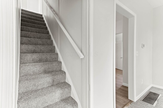 378 Maple Ave, Newark, OH 43055 - stairway with visible vents, carpet flooring, baseboards, and wood finished floors
