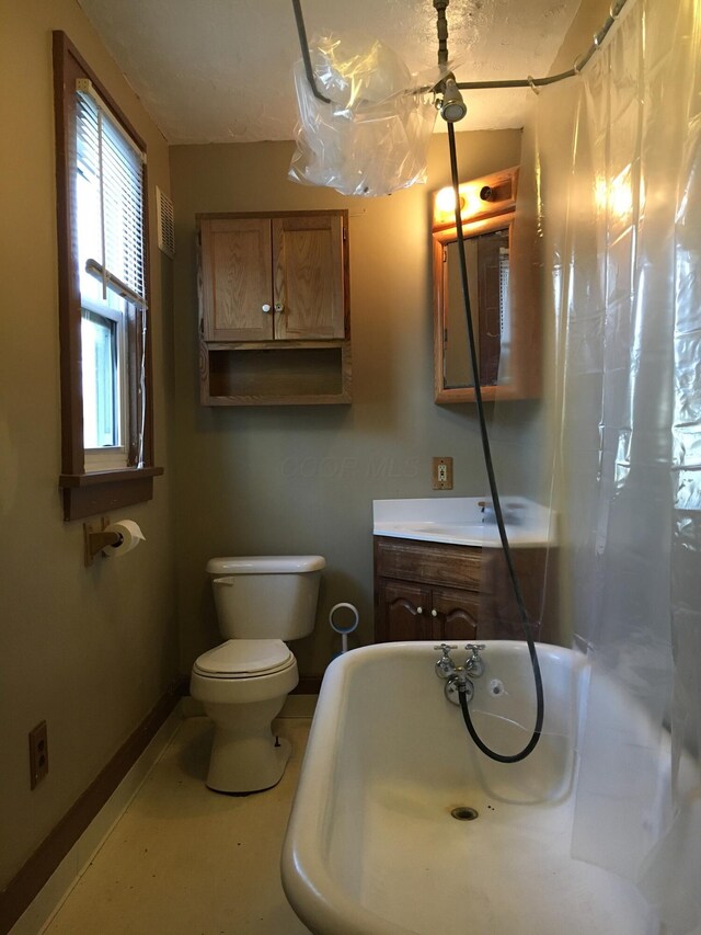 438 E 15th Ave, Columbus, OH 43201 - bathroom with vanity, baseboards, a bath, and toilet