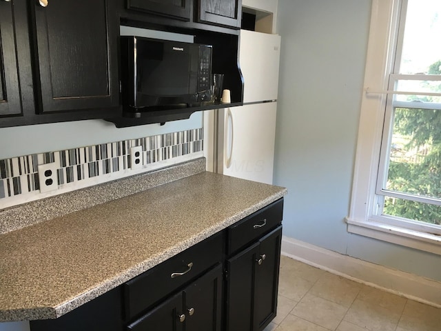 438 E 15th Ave, Columbus, OH 43201 - kitchen featuring dark cabinets, tasteful backsplash, black microwave, and baseboards